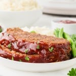 Two slices of Meatloaf made in a Crockpot served on a white plate.