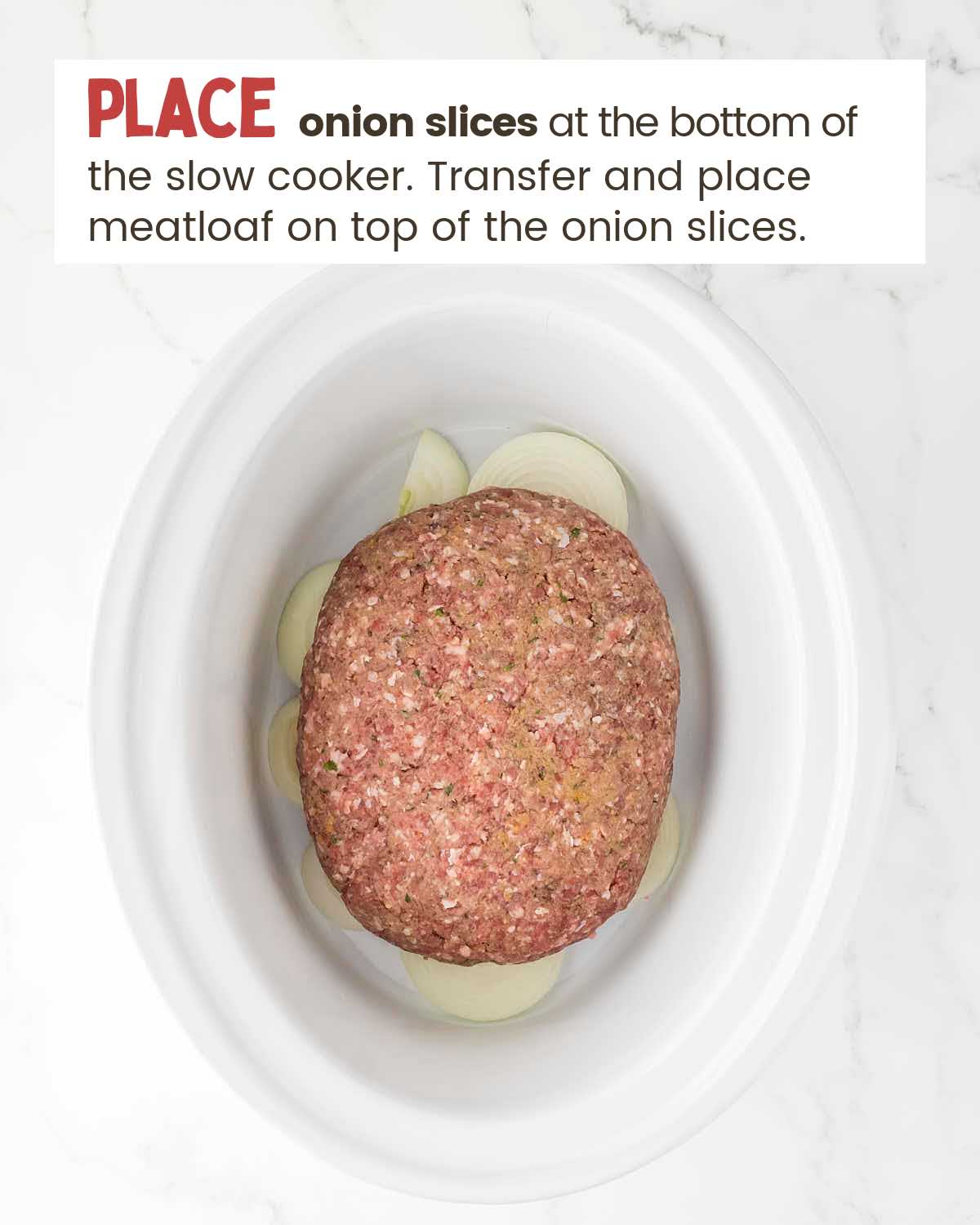 An oval shaped meatloaf sits on sliced onions in a slow cooker.