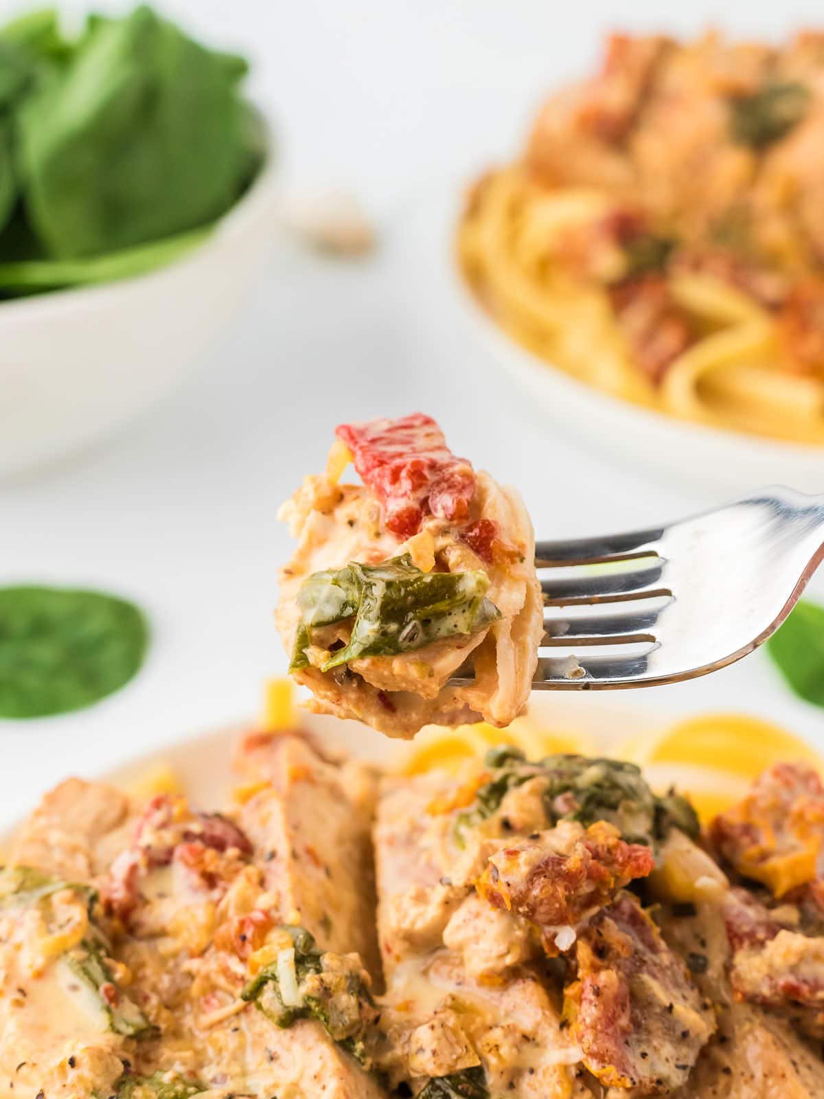 A forkful of Crockpot Tuscan Chicken with pasta.