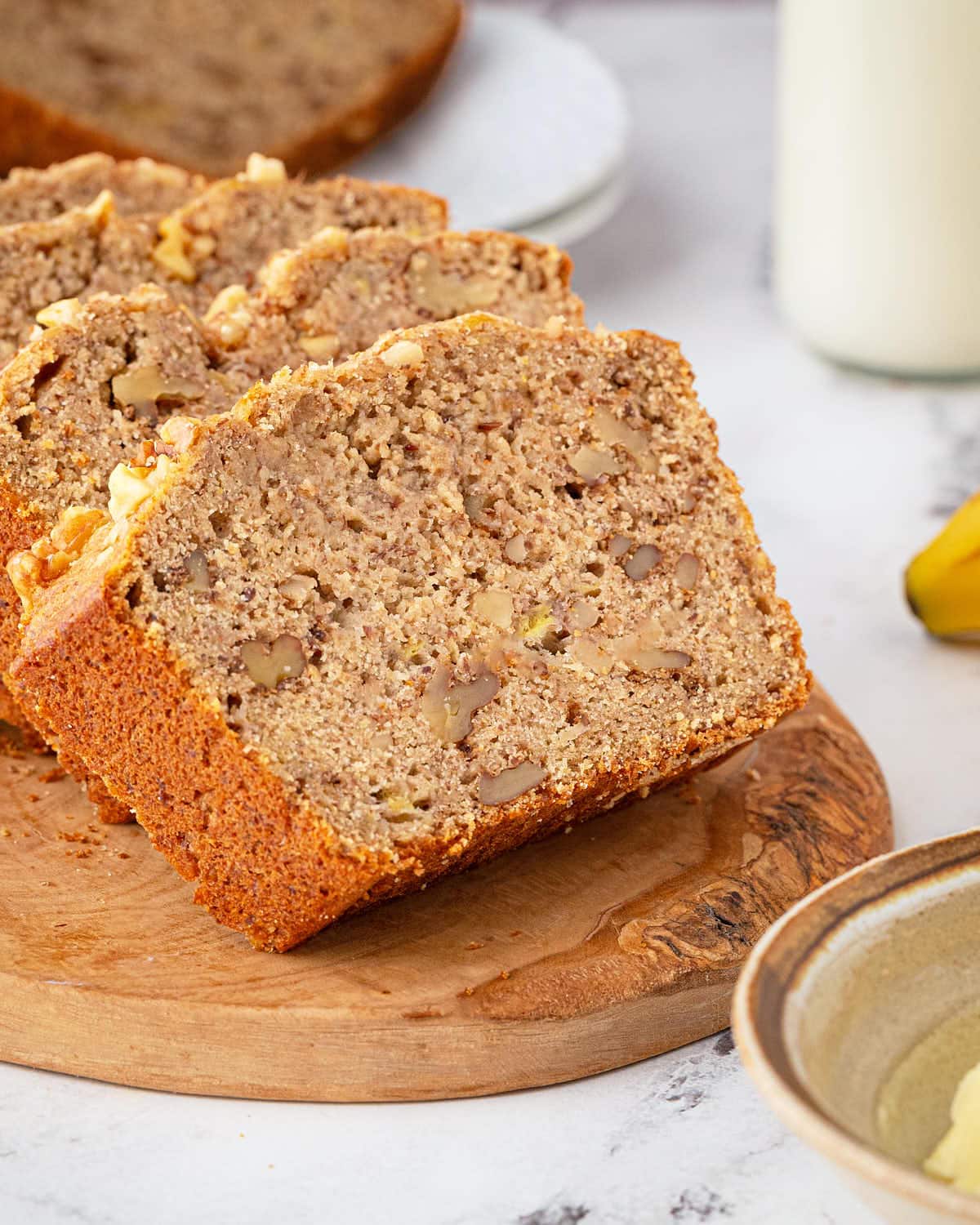Slices of Sourdough Banana Bread on wooden serving plate.