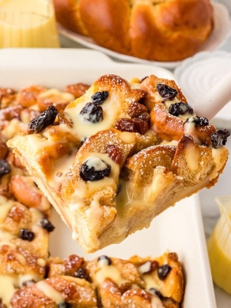 Lifting a slice of Bread Pudding out of a baking dish.