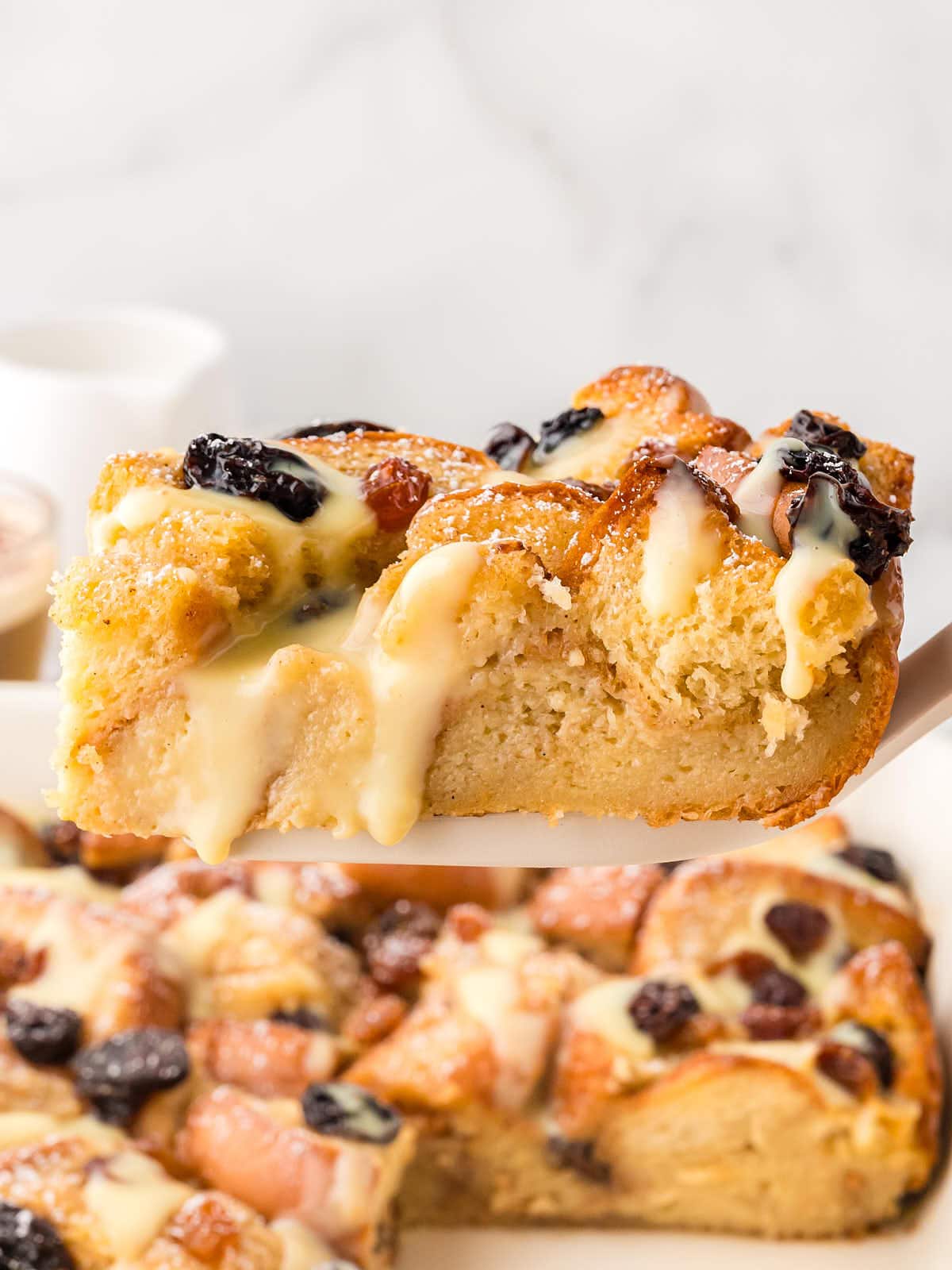 Lifting a slice of Bread Pudding out of the baking dish.