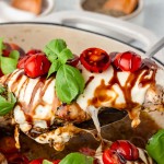 A serving spoon holding a slice of Chicken Caprese out of the skillet.