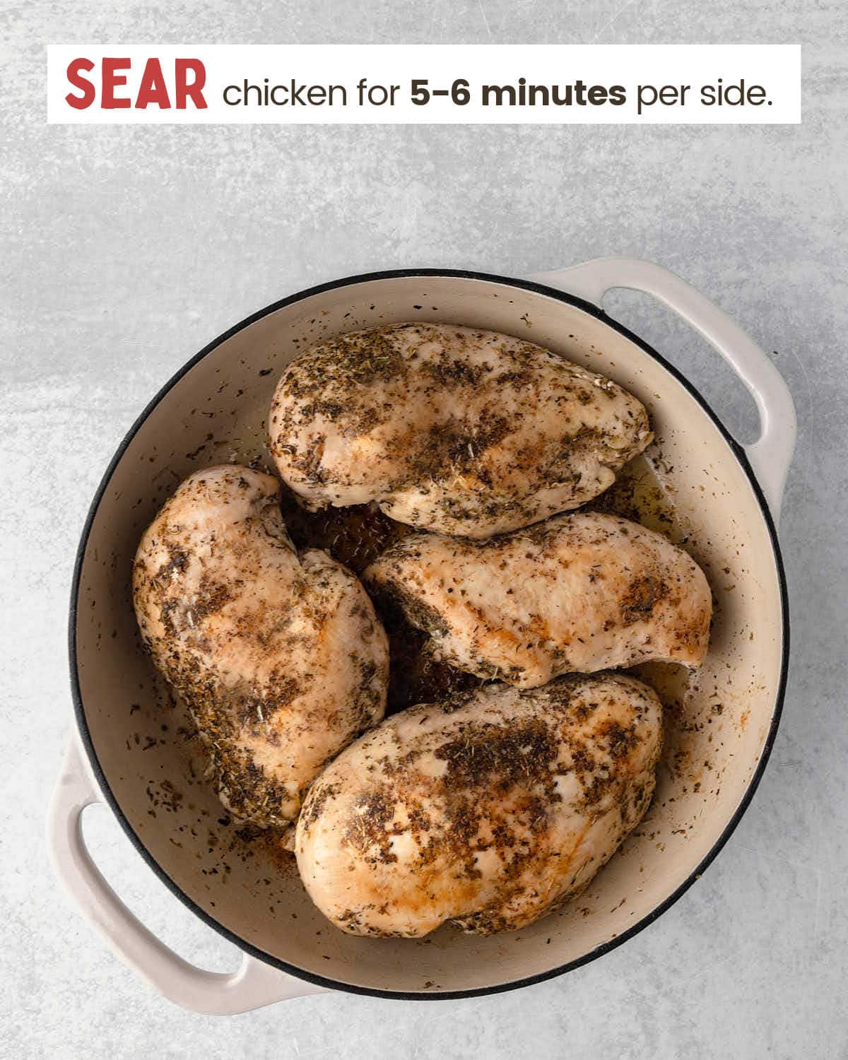 Seared chicken breasts seasoned with salt, pepper, and Italian seasonings in a skillet.