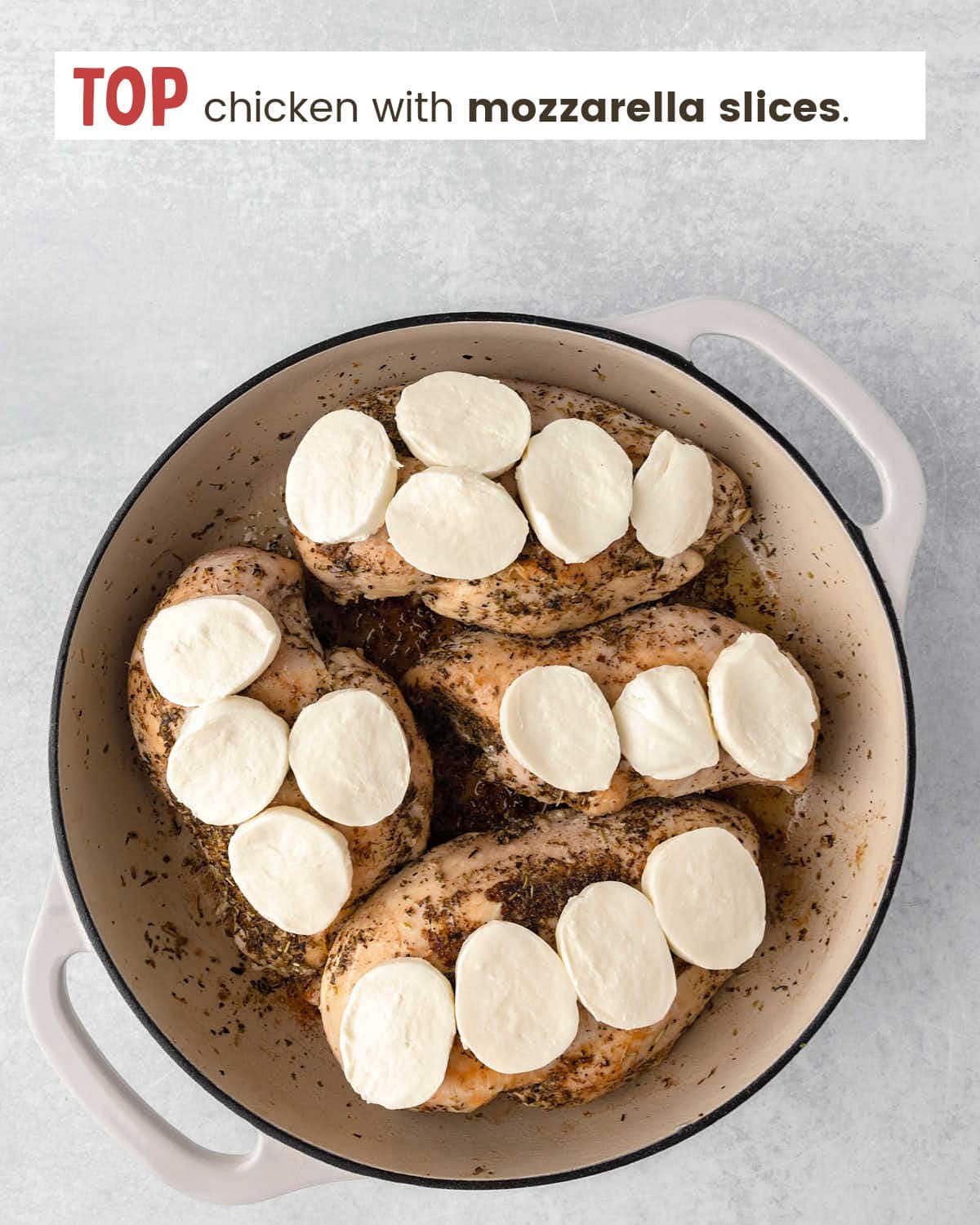 Seared chicken breasts topped with mozzarella slices in a skillet.