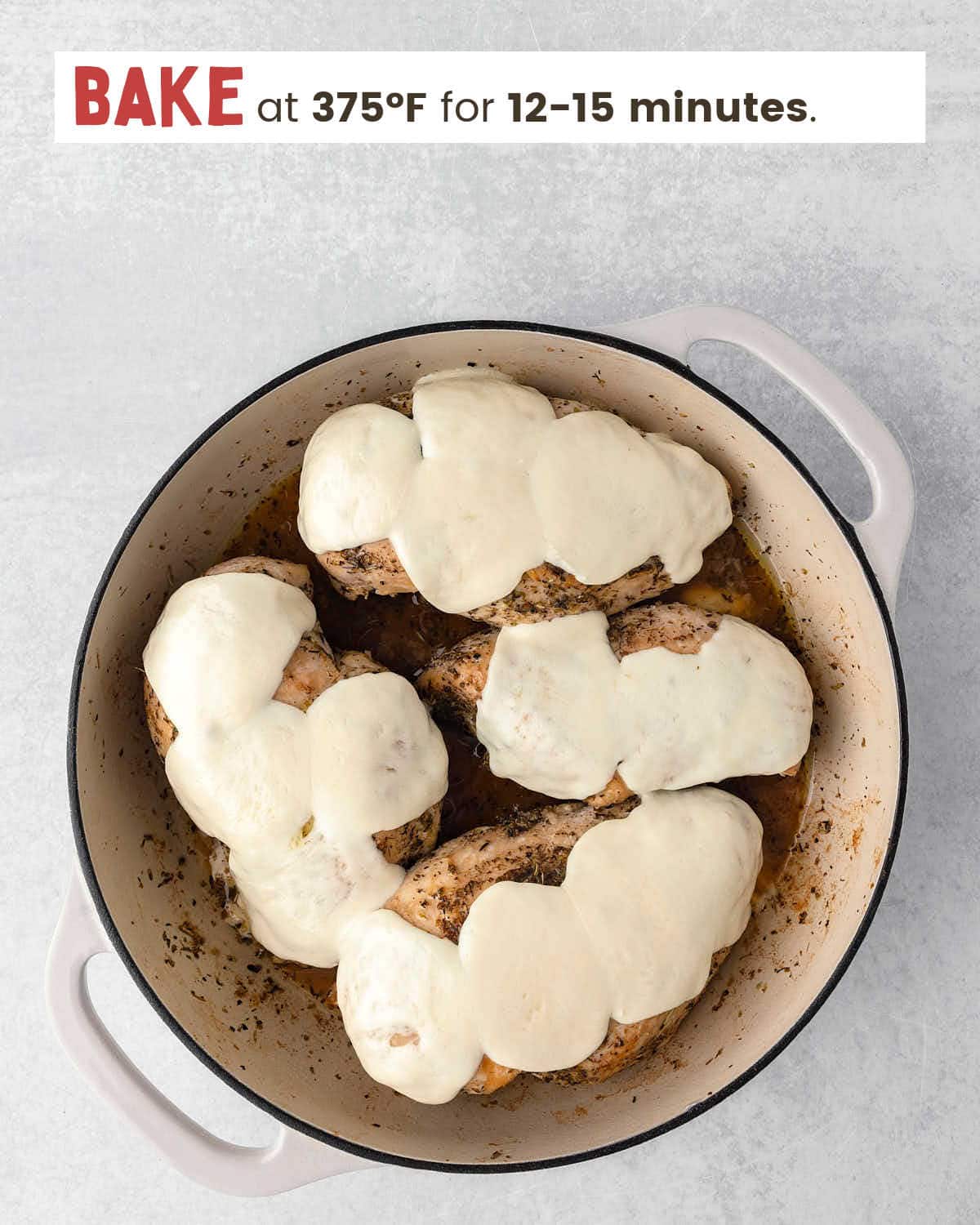 Seared chicken breasts topped with melted mozzarella slices in a skillet.