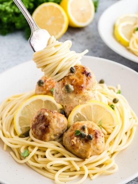 A forkful of spaghetti with a Chicken Piccata Meatball.