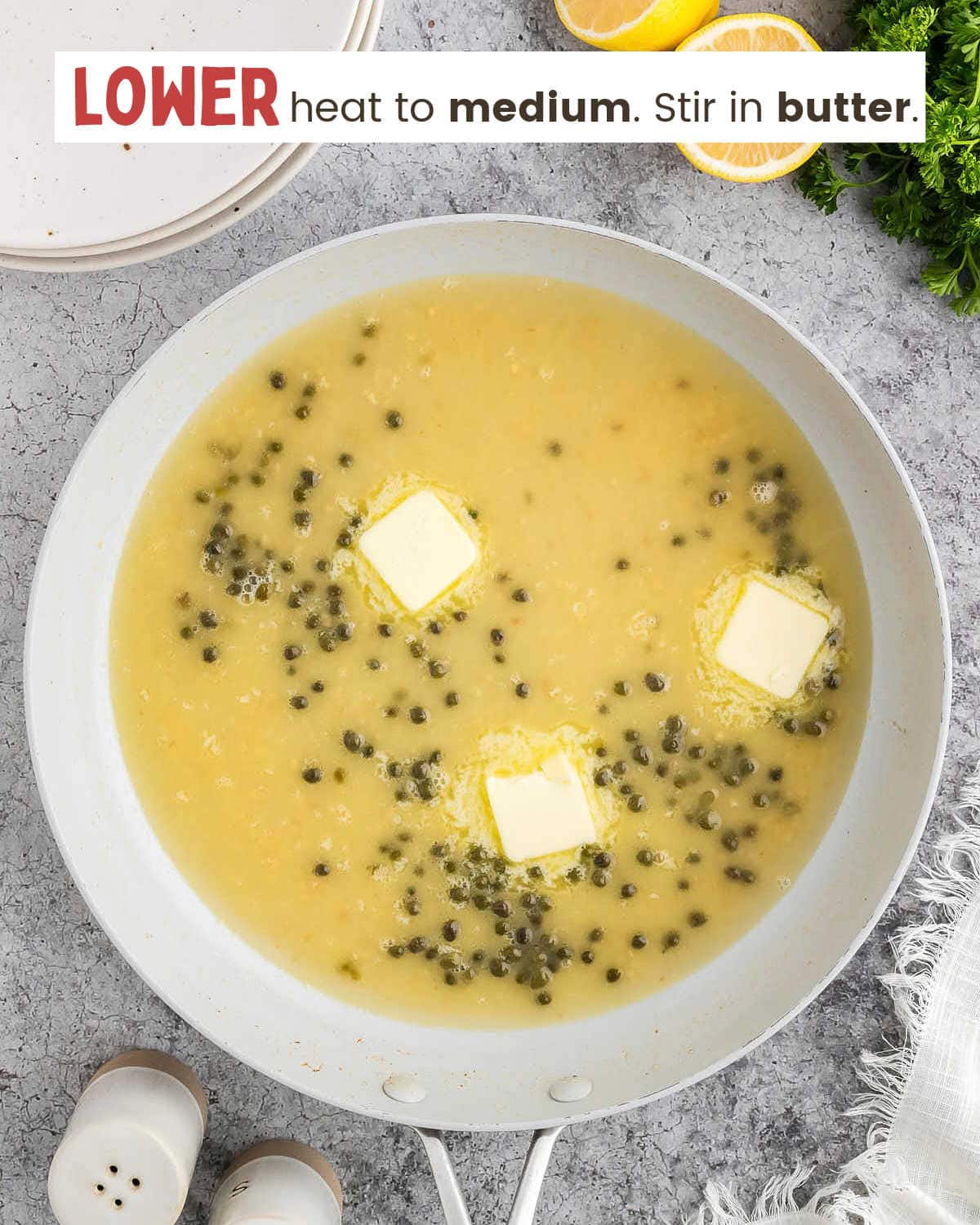 Chicken broth, capers, white wine, butter pats, and garlic in a skillet.