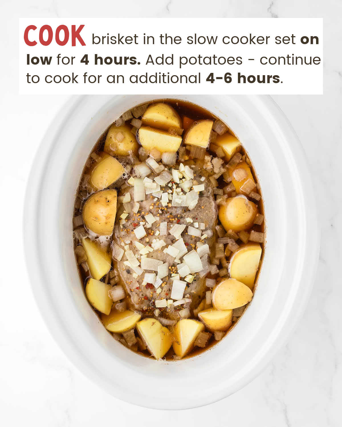 Potato chunks around a corned beef brisket topped with onions in a slow cooker.