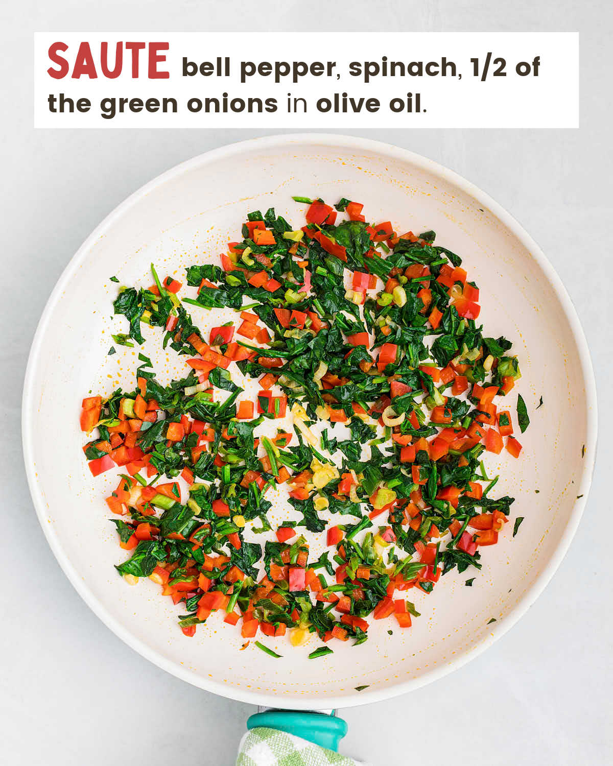 Chopped bell peppers, chopped spinach, chopped green onions in a skillet. 