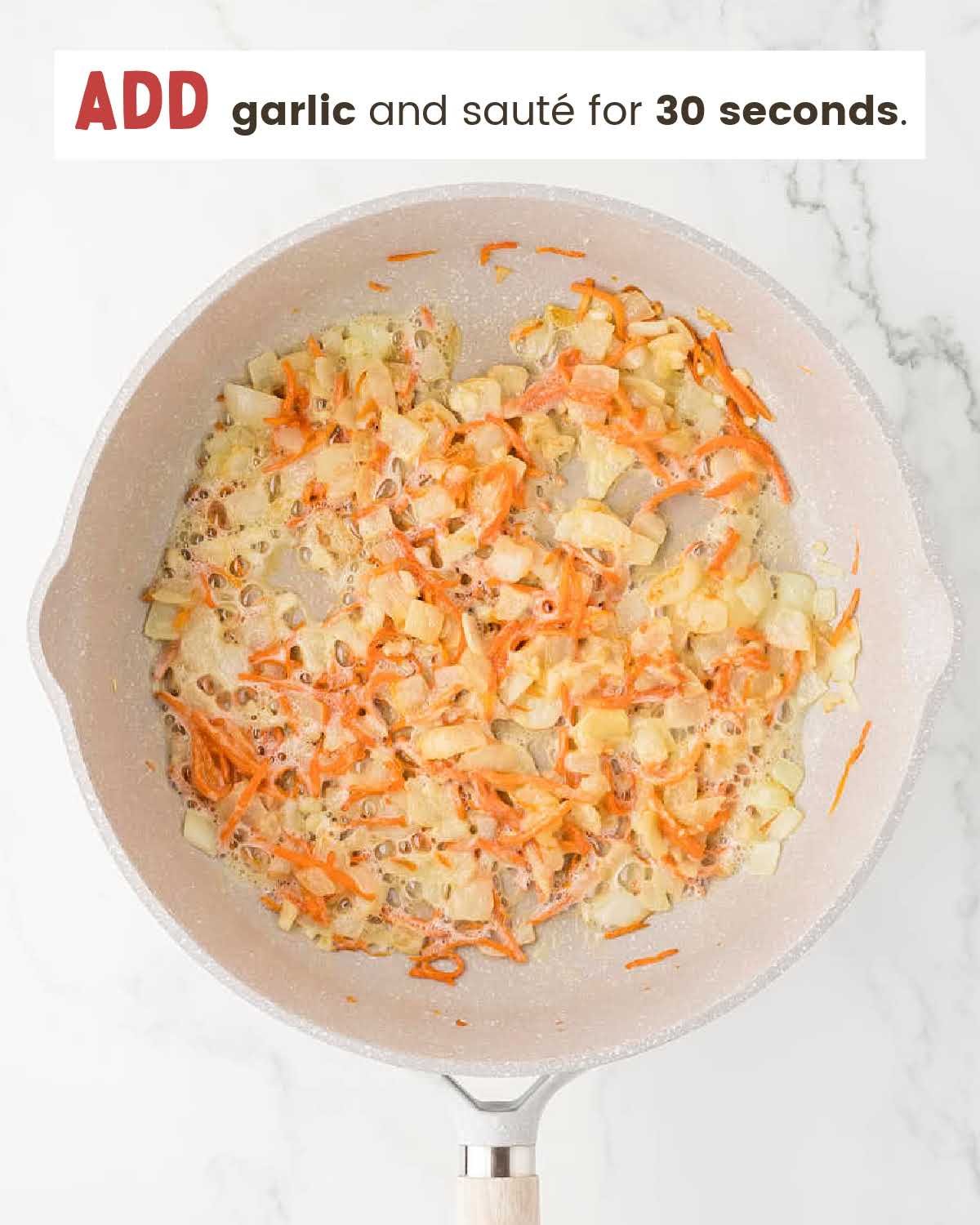 Carrots, garlic, and chopped onions sautéing in a skillet.