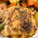 Closeup of a Slow Cooker chicken thigh on a white plate.