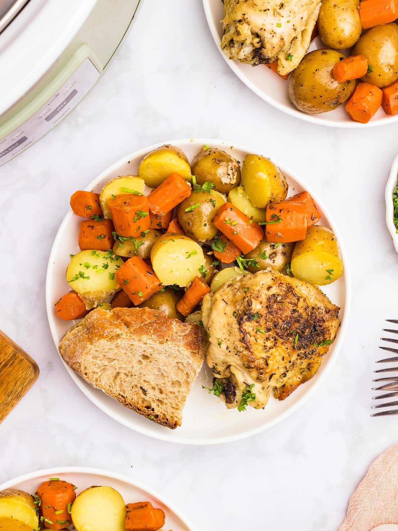Topdown view of Crockpot Chicken and Potatoes on a white plate.