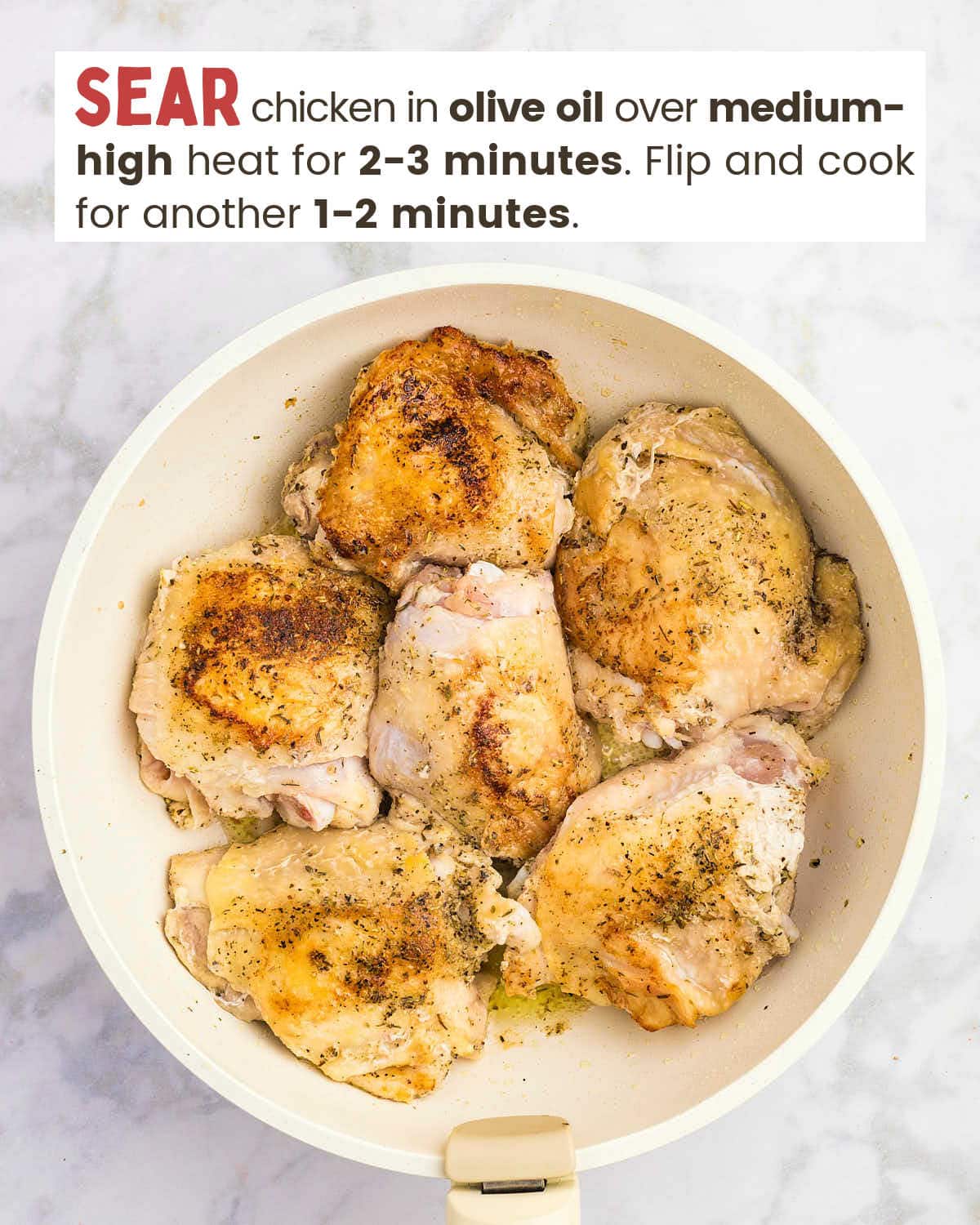 Seared chicken thighs in a skillet.