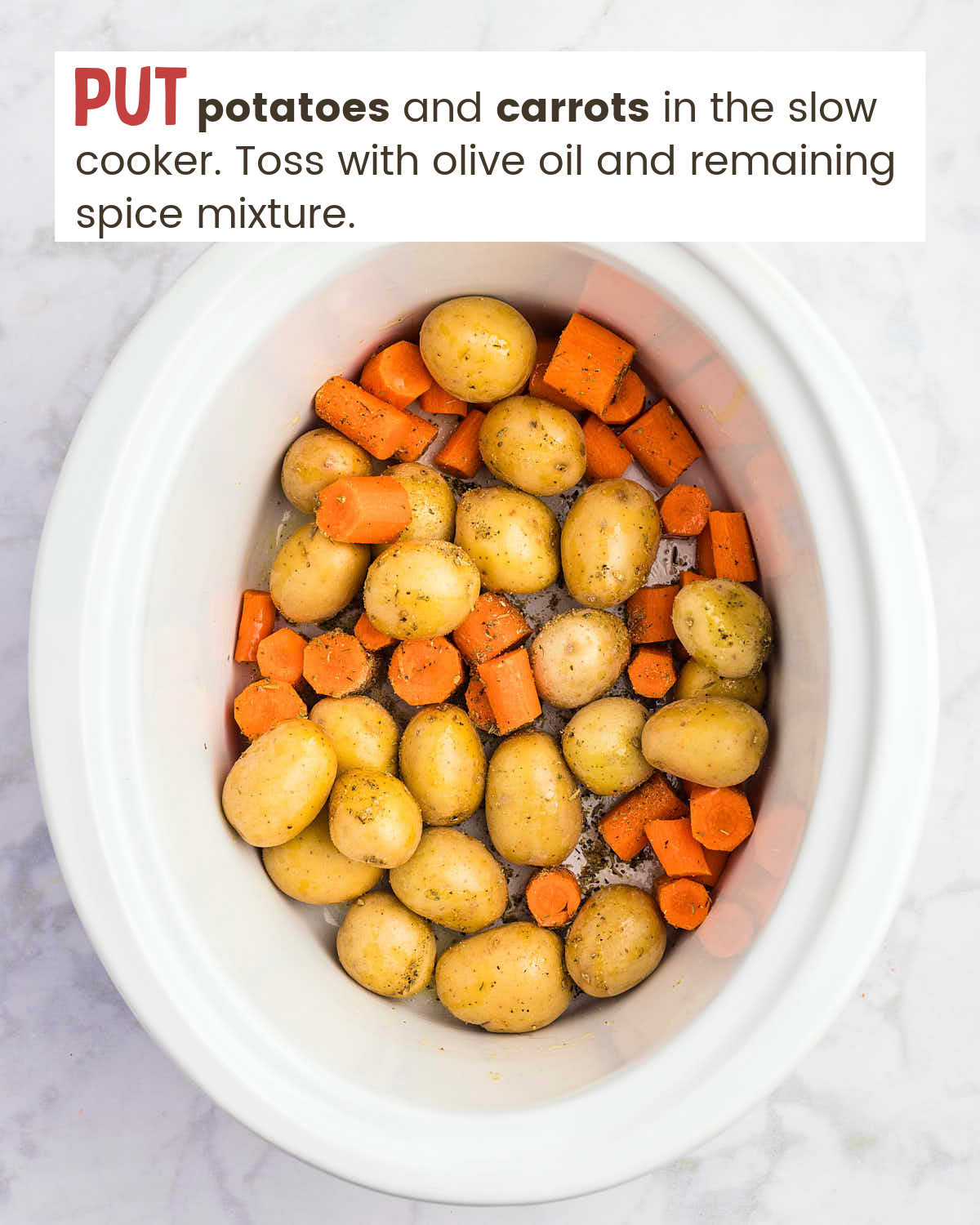 Small potatoes and chopped carrots in a slow cooker.