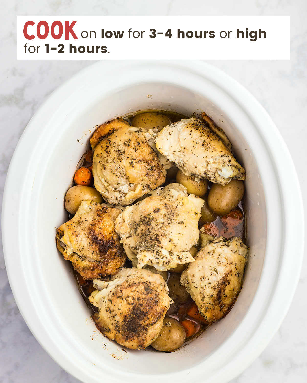 Chicken thighs, potatoes and chopped carrots in a slow cooker.