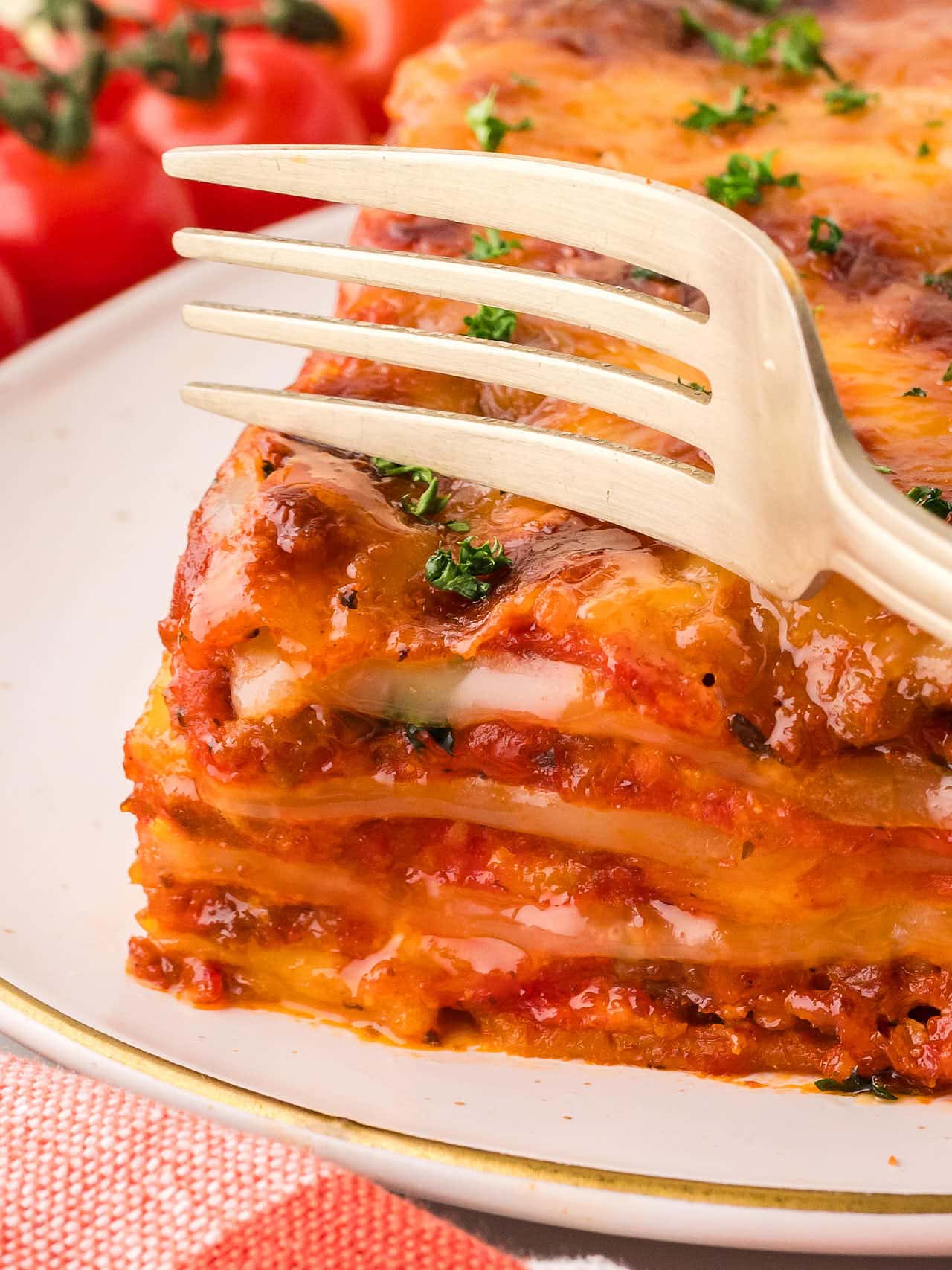 A fork digging into a slice of Lasagna.