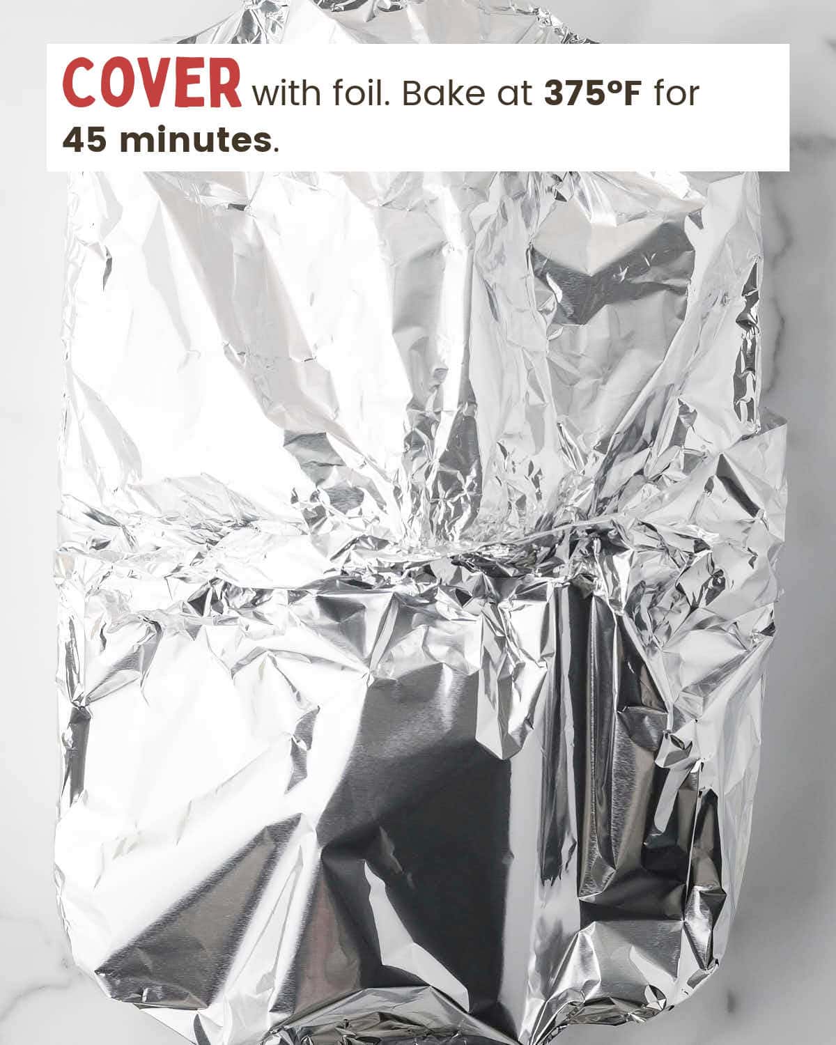 Foil covers lasagna in a baking dish.