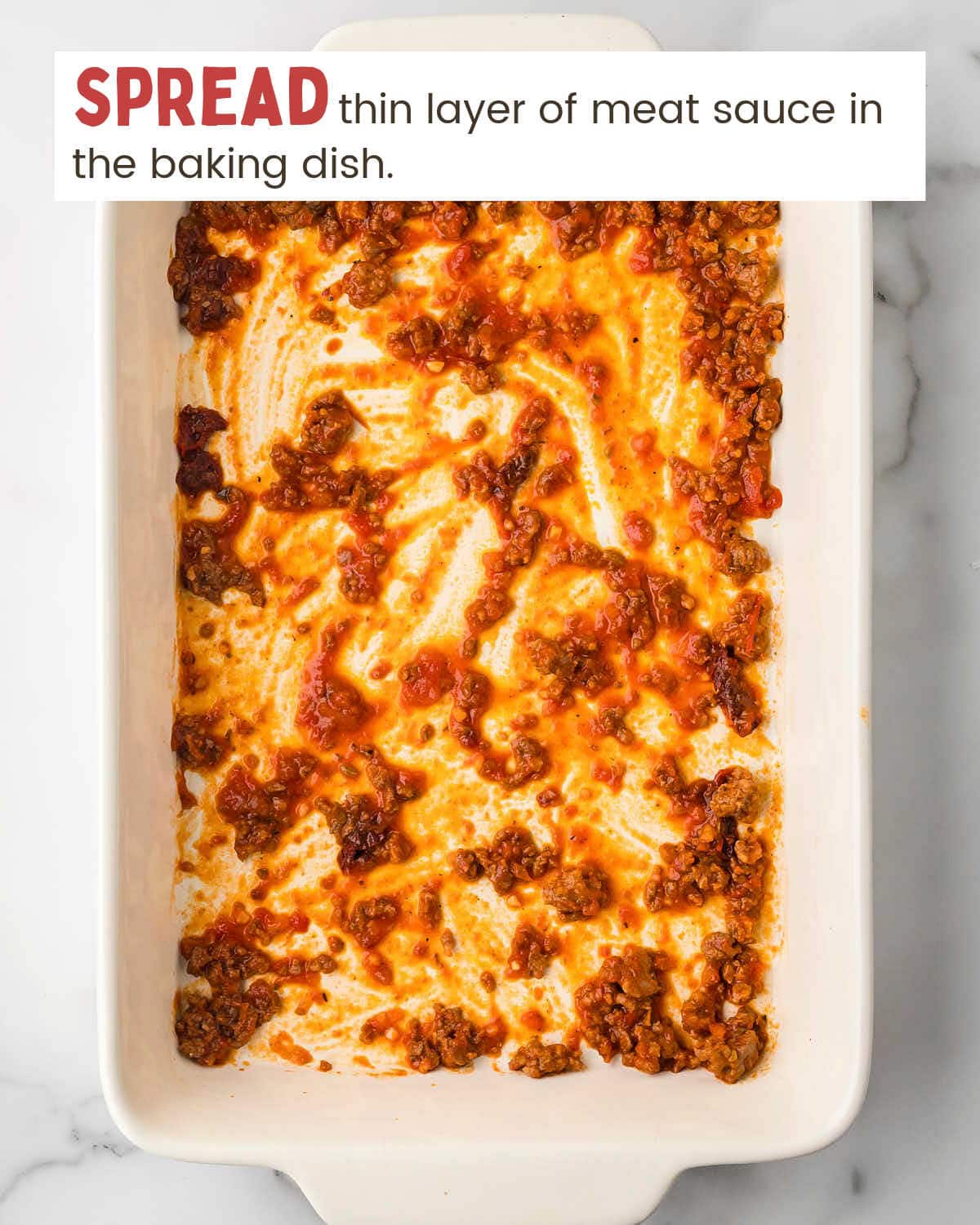 Thin meat sauce layer in a baking dish.