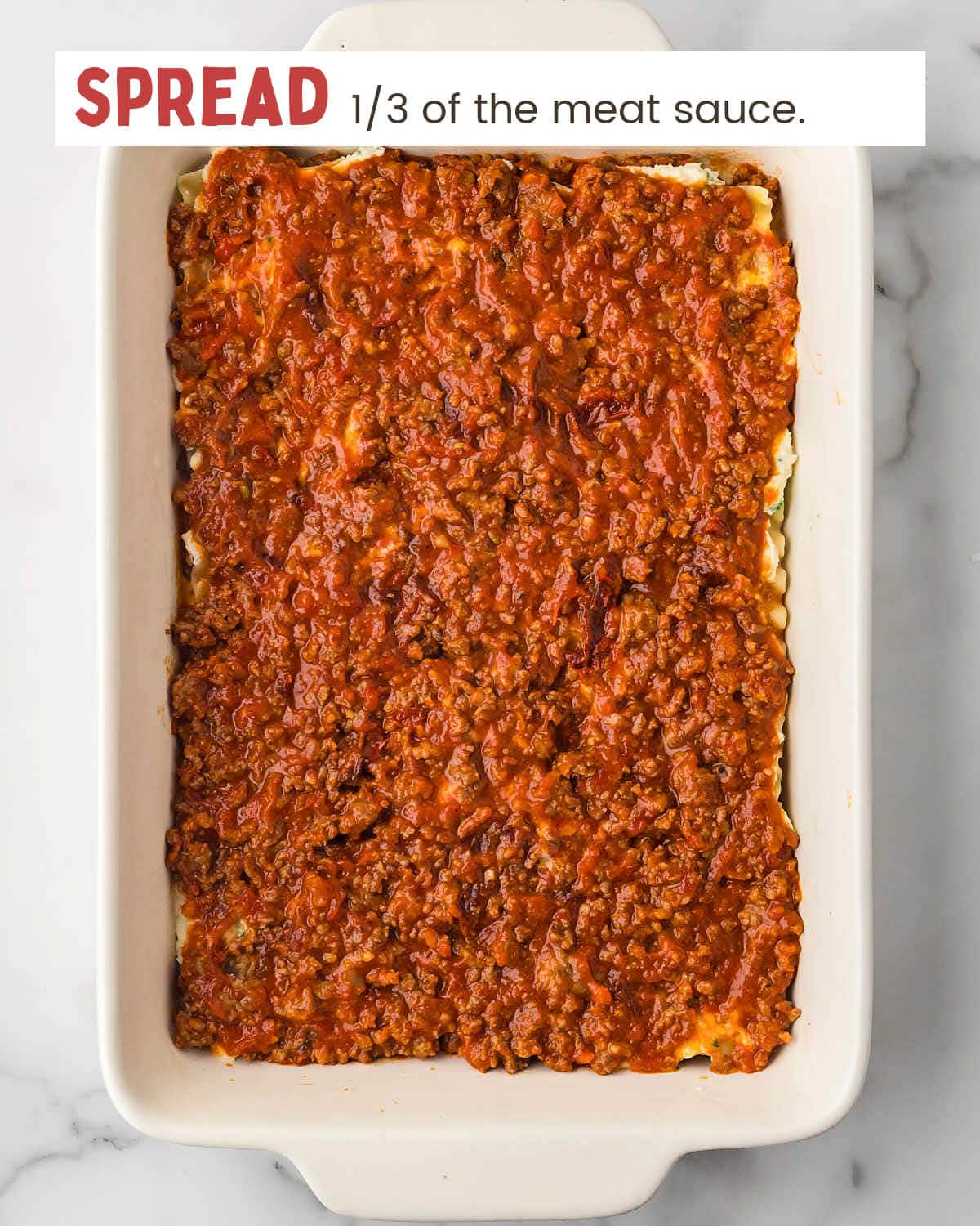Meat sauce layer of lasagna in a baking dish.