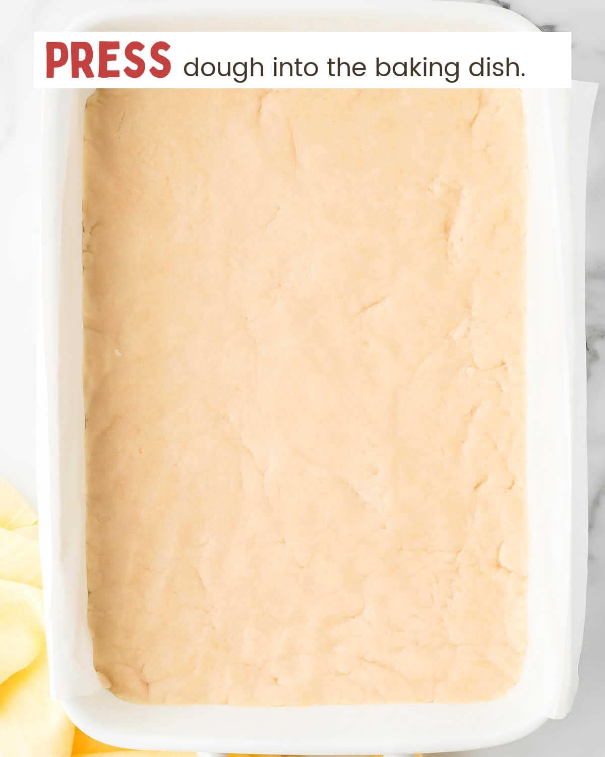 Dough pressed into a baking dish.