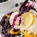 Pouring blueberry sauce over the Lemon Blueberry Dump Cake served with vanilla ice cream.