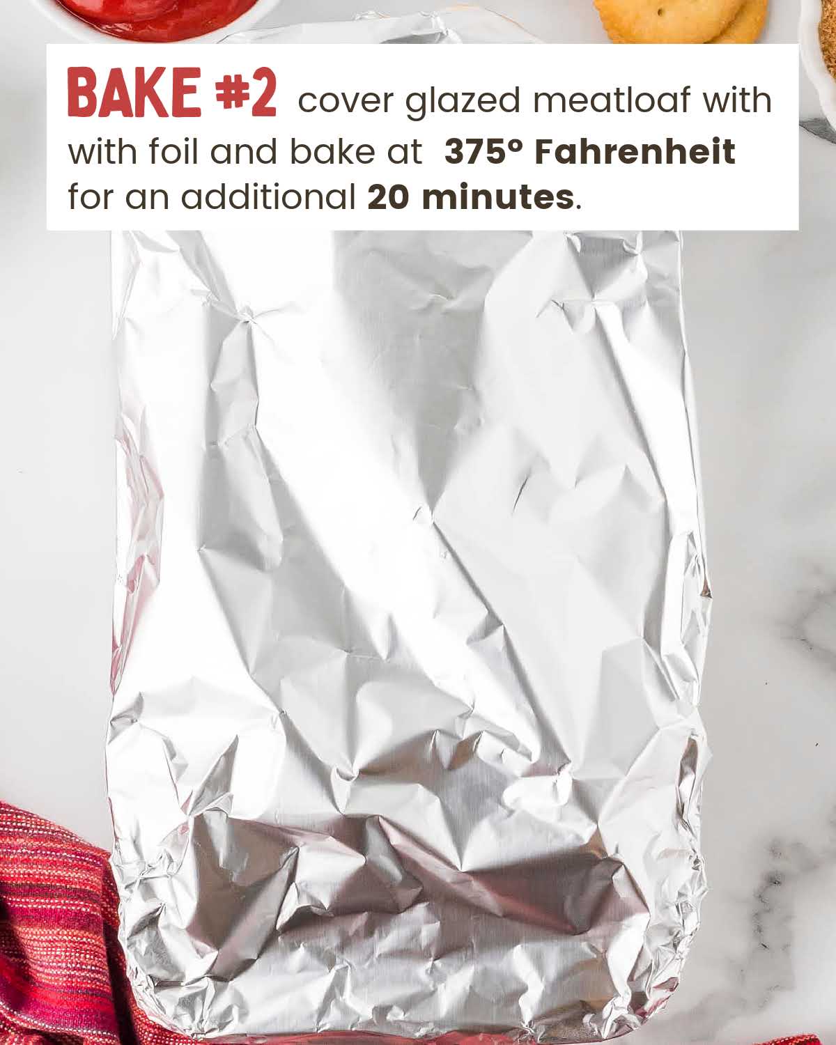 Aluminum foil covers meatloaf in a parchment lined loaf pan.