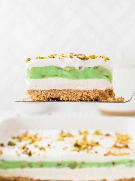 A slice of Pistachio Lush on a serving spatula.