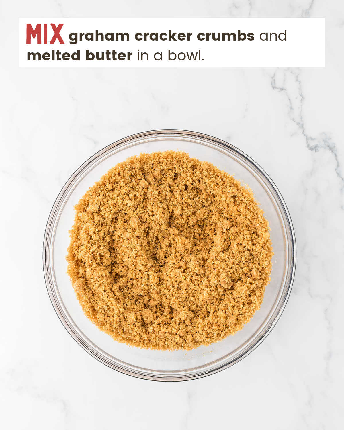 Graham cracker crumbs with melted butter in a mixing bowl.