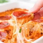 Scooping out a Pizza Dip with slice of baguette.