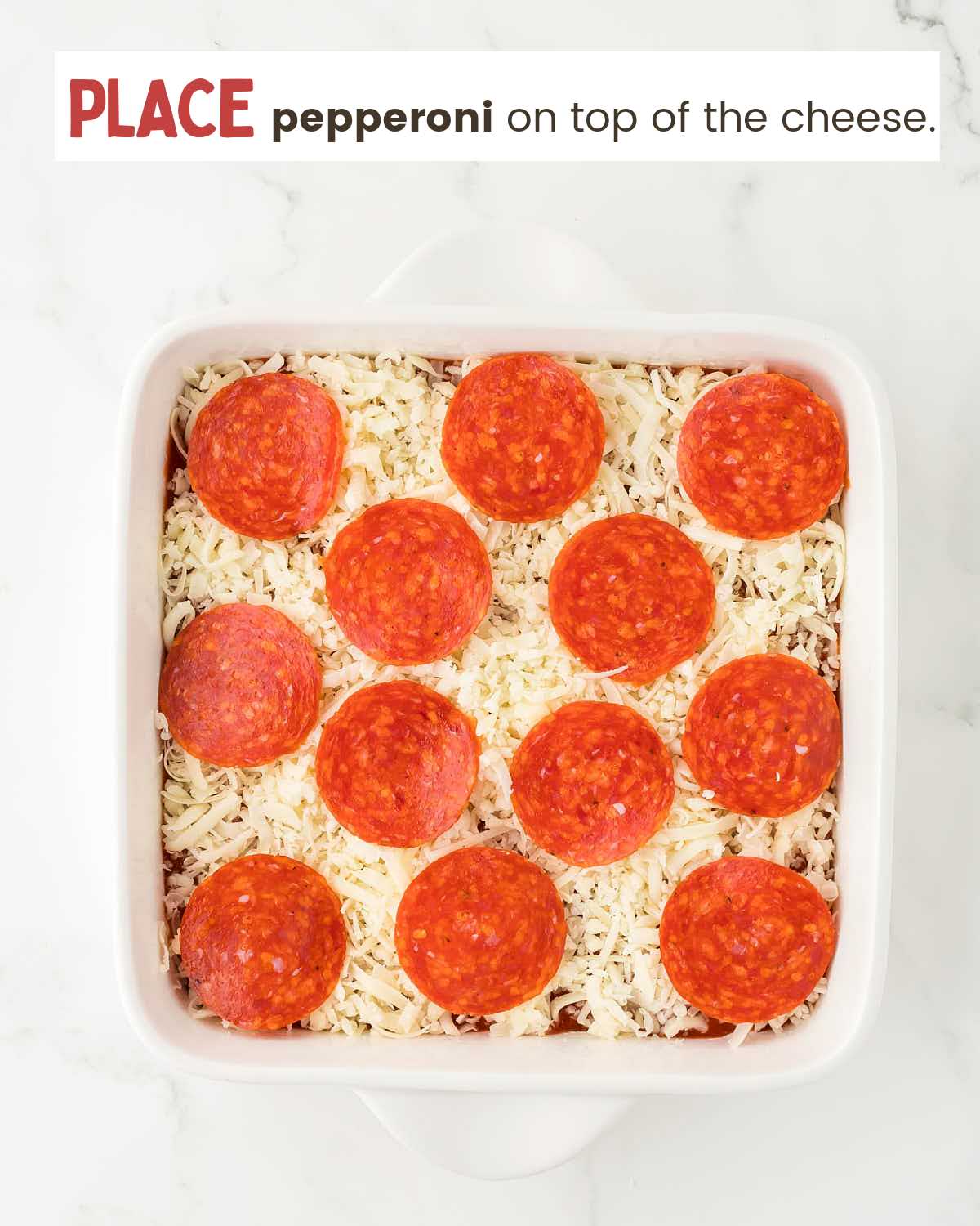 Pepperoni slices on top of a pizza dip in a dish.