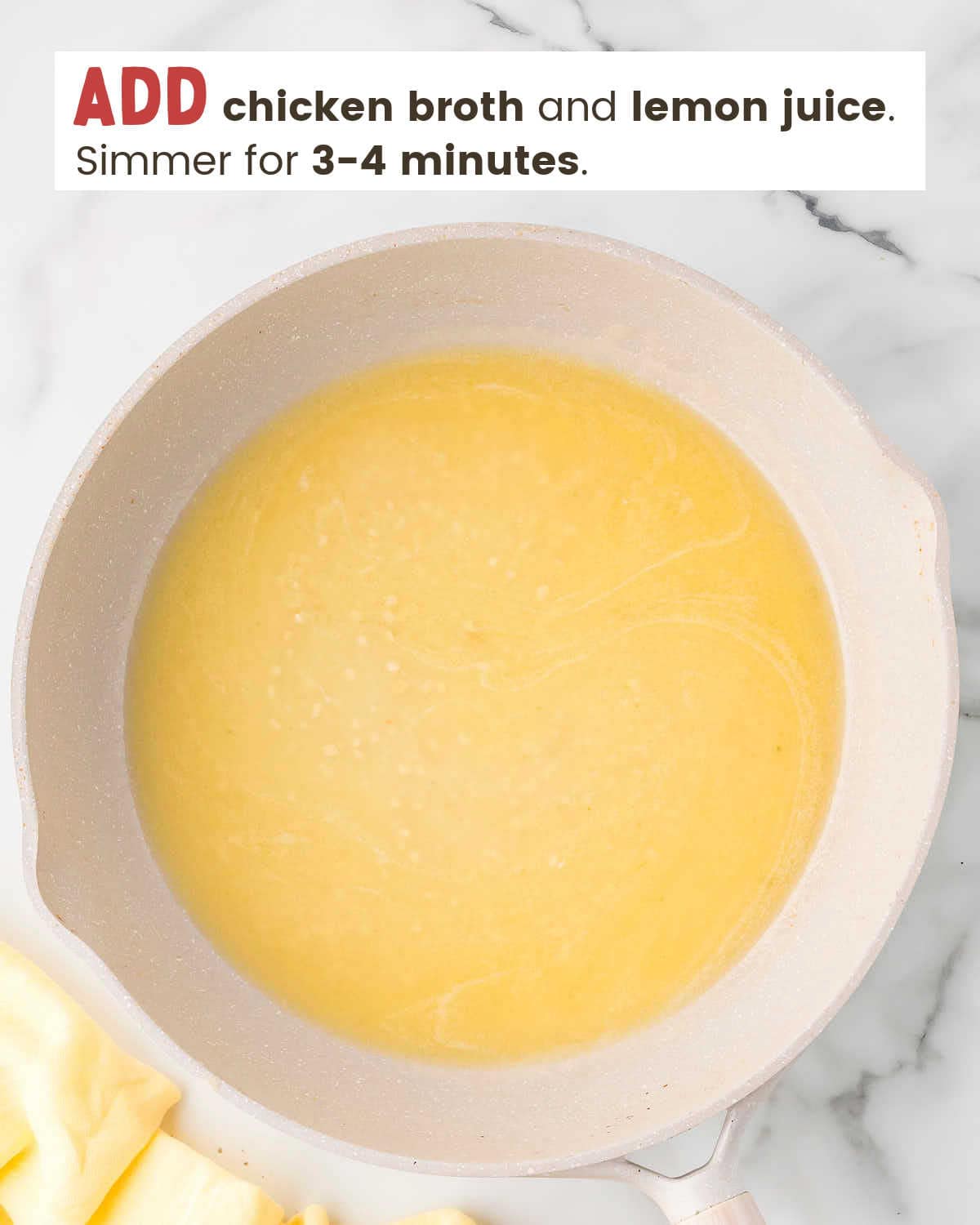 Chicken broth with garlic in a skillet.