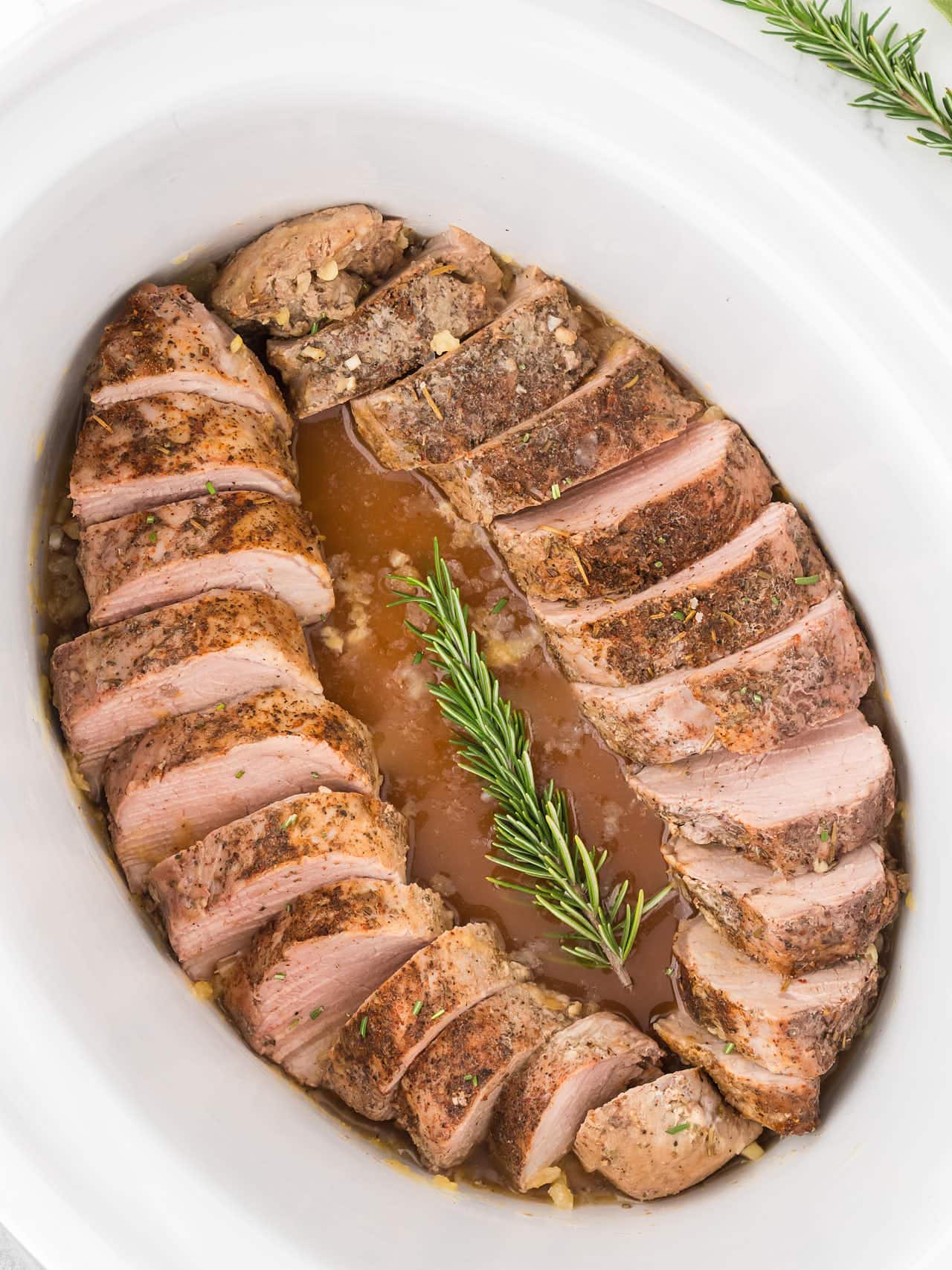 Top down view of a sliced Pork Tenderloin in a Slow Cooker.