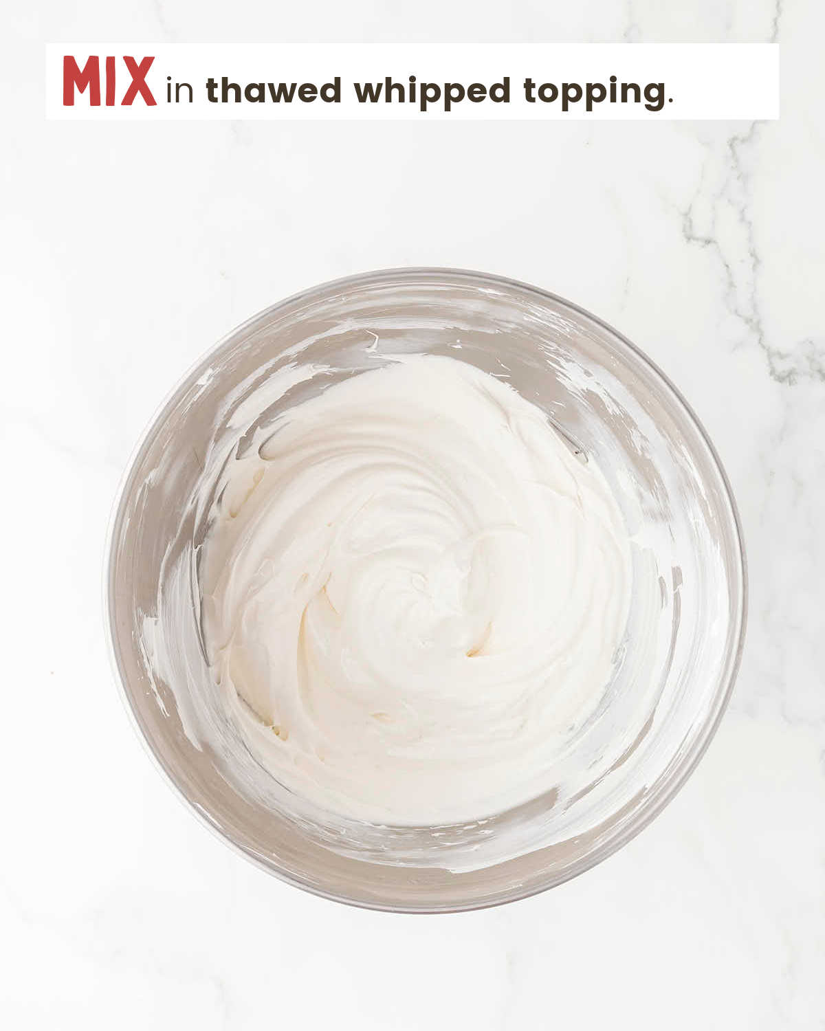 Cream cheese and whipped topping mixture in a mixing bowl.