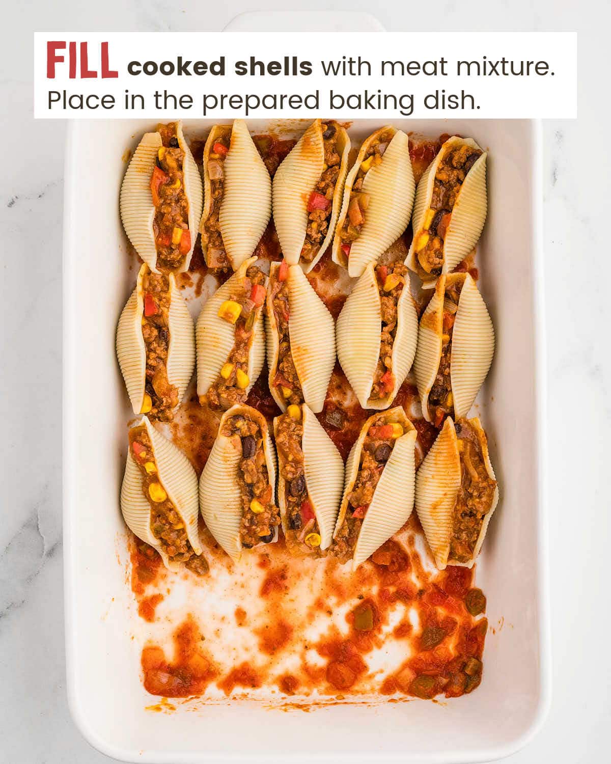 Pasta shells stuffed with beef mixture in a baking dish.
