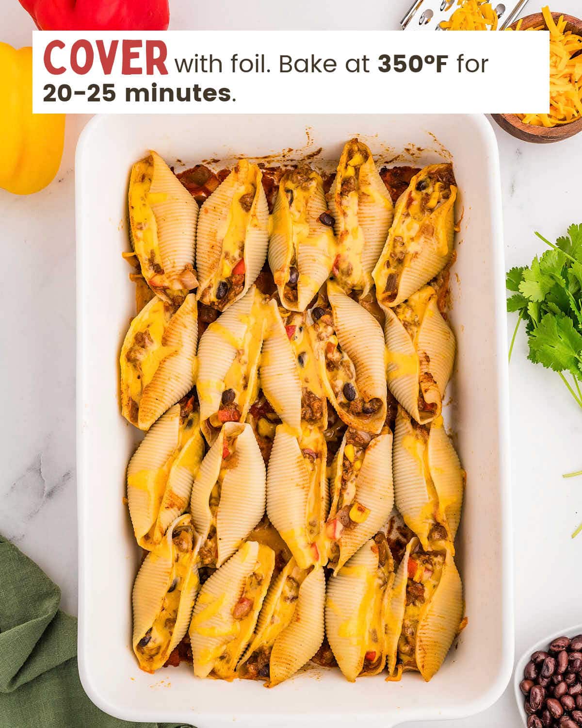Stuffed pasta shells topped with cheese in a baking dish.
