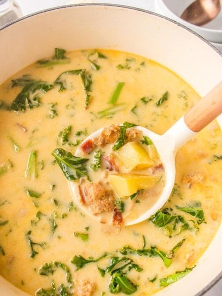 Top down view of a ladle filled with Zuppa Toscana.