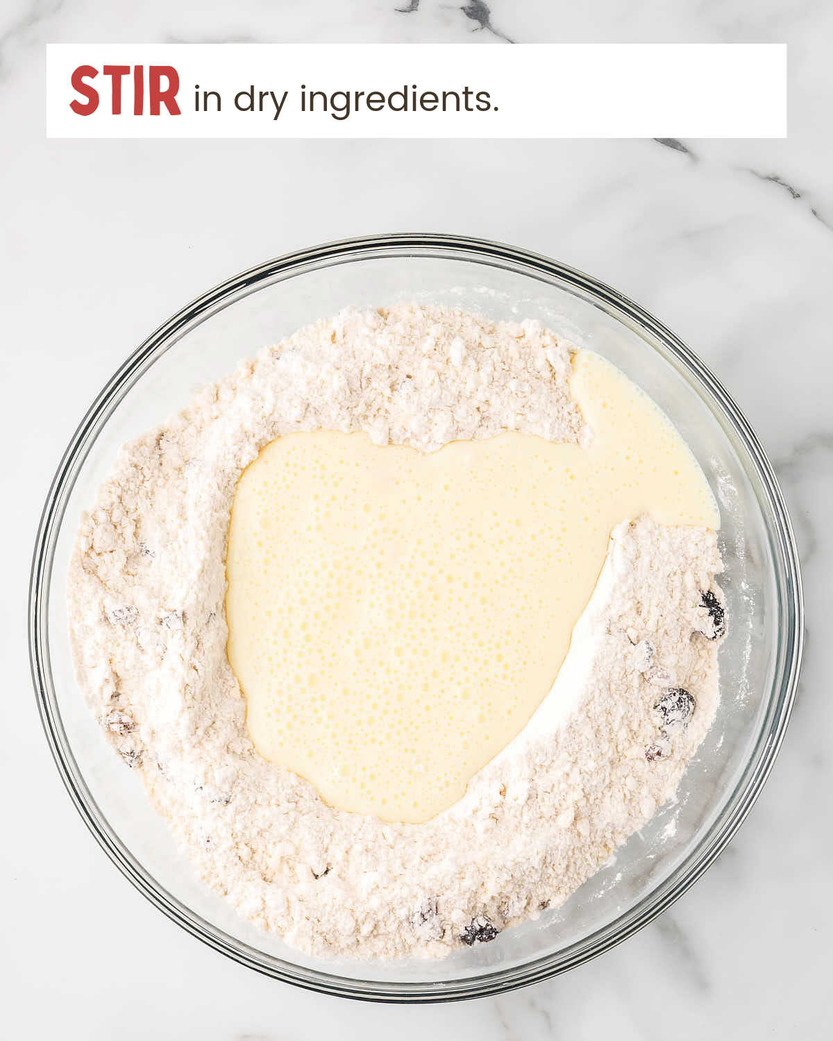 Whisked buttermilk and egg with flour mixture on top in a bowl.