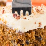 A fork digging into a slice of Carrot Cake.