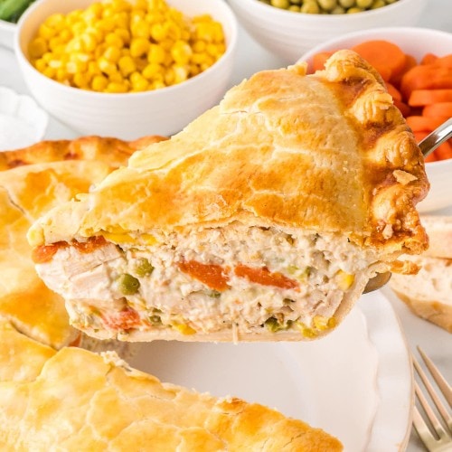 A slice of Chicken Pot Pie being lifted out of the pan.