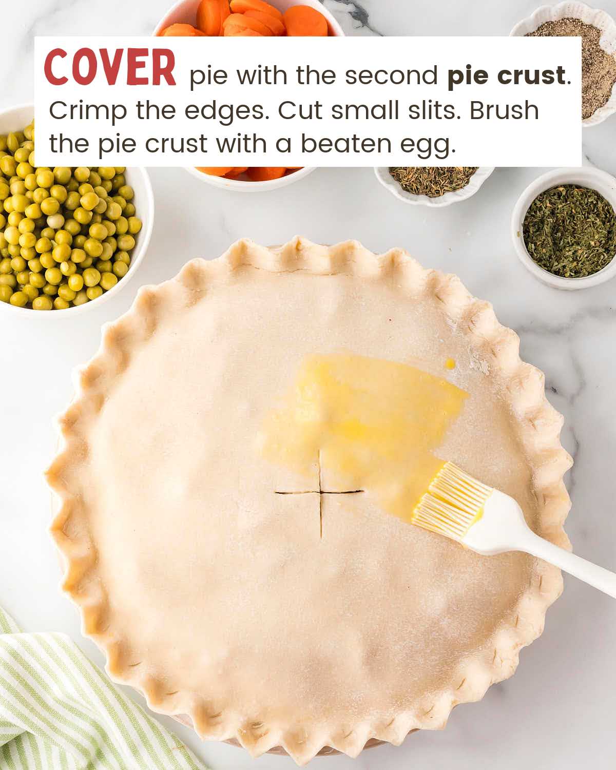 A brush with beaten egg on a chicken pot pie crust.