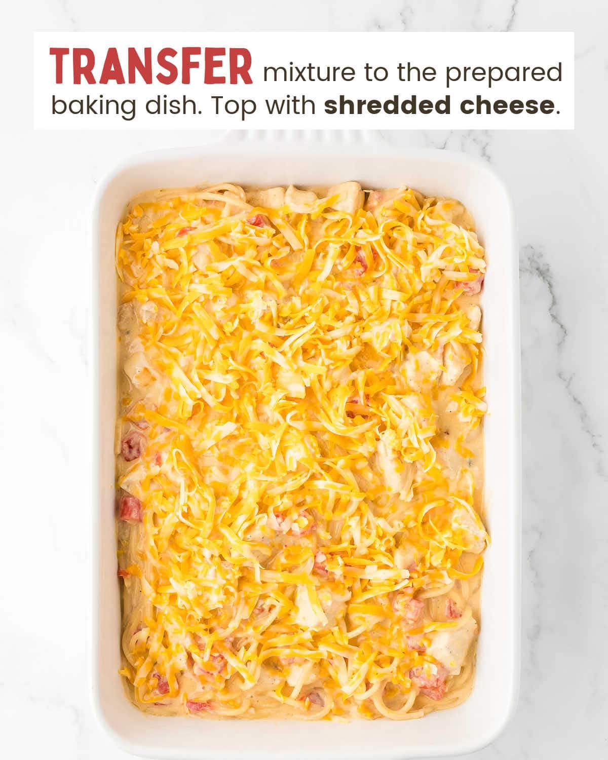 Spaghetti and chicken in a cheesy Rotel sauce topped with shredded cheese in a baking dish.