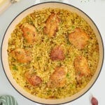 Topdown view of cooked Chicken Thighs and Rice in a white skillet.