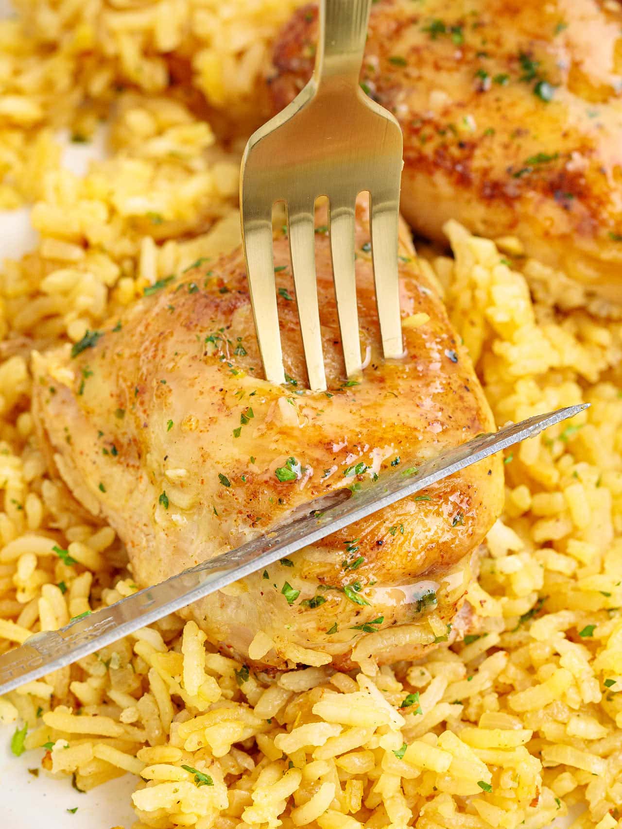 Cutting a cooked chicken thigh.