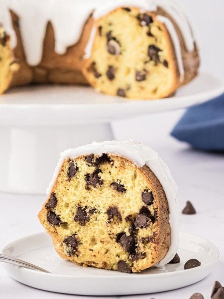 A slice of frosted Chocolate Chip Bundt Cake.