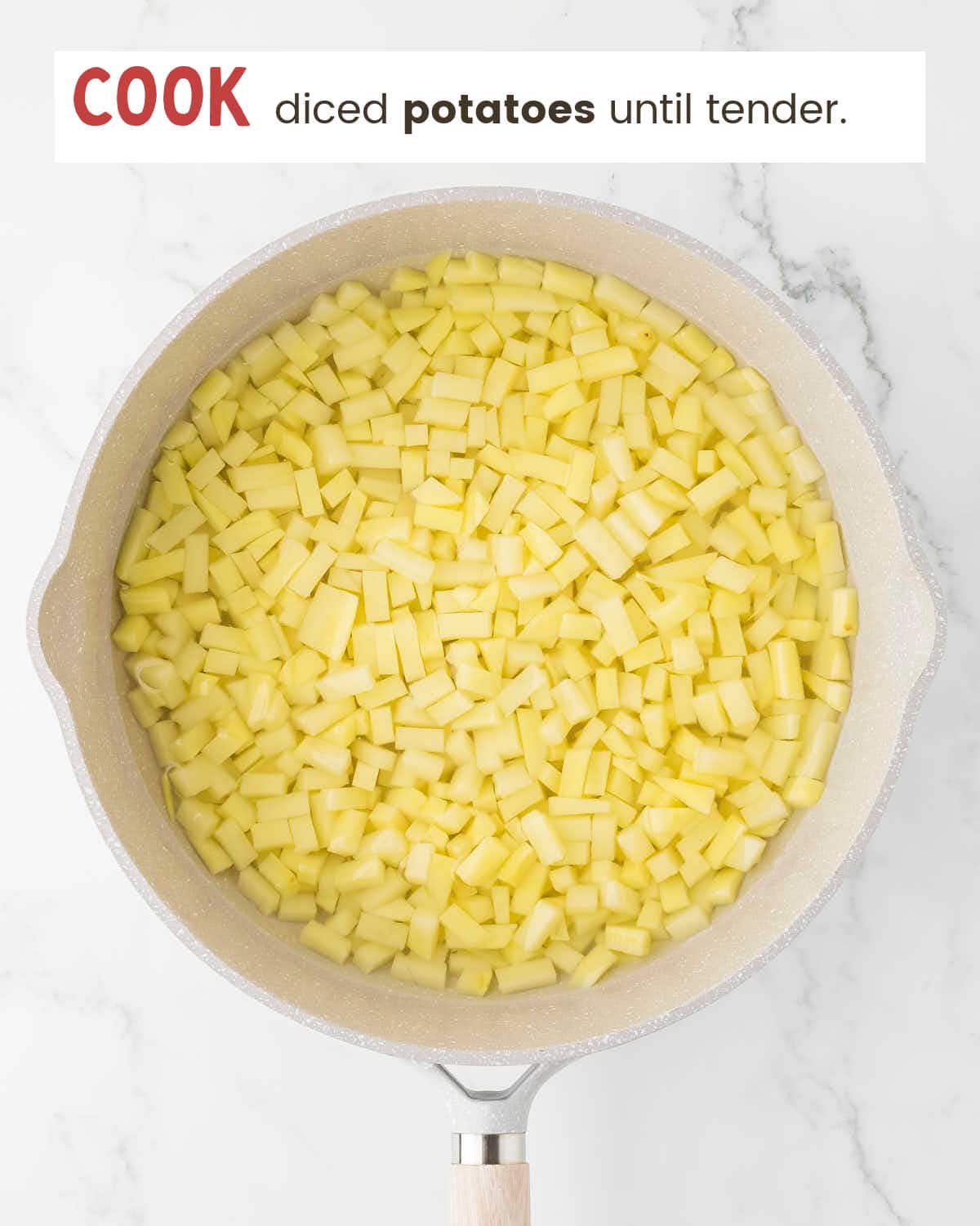 Cook diced potatoes in a white skillet.