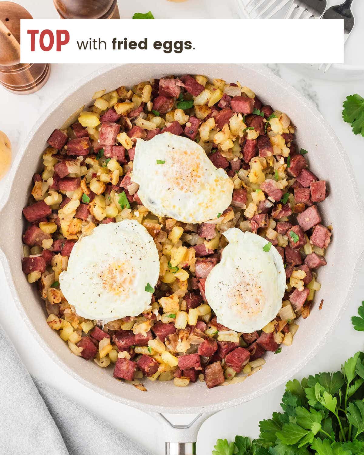 Skillet with Corned Beef Hash topped with fried eggs.