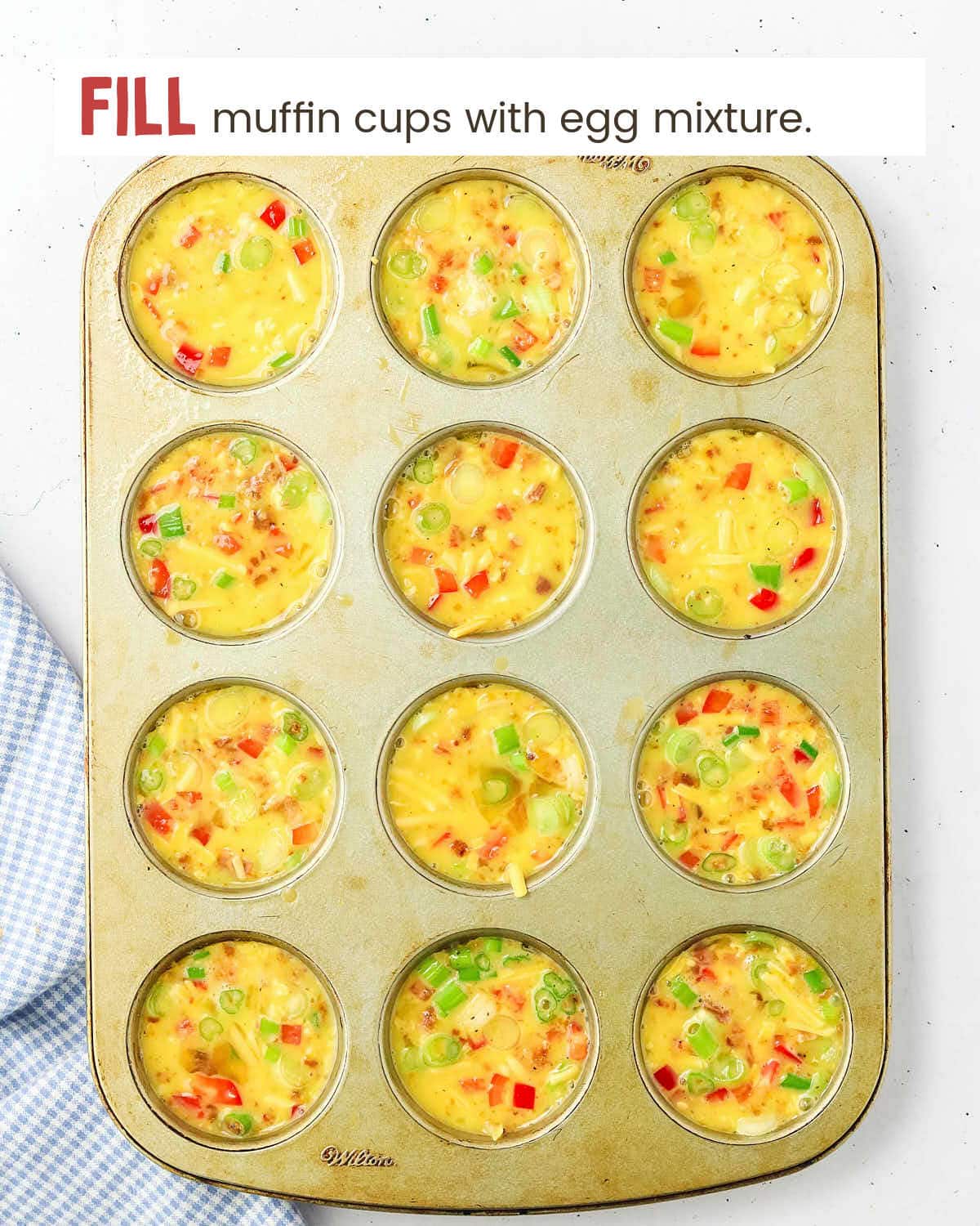 Egg omelet mixture in muffin cups in a muffin tin.