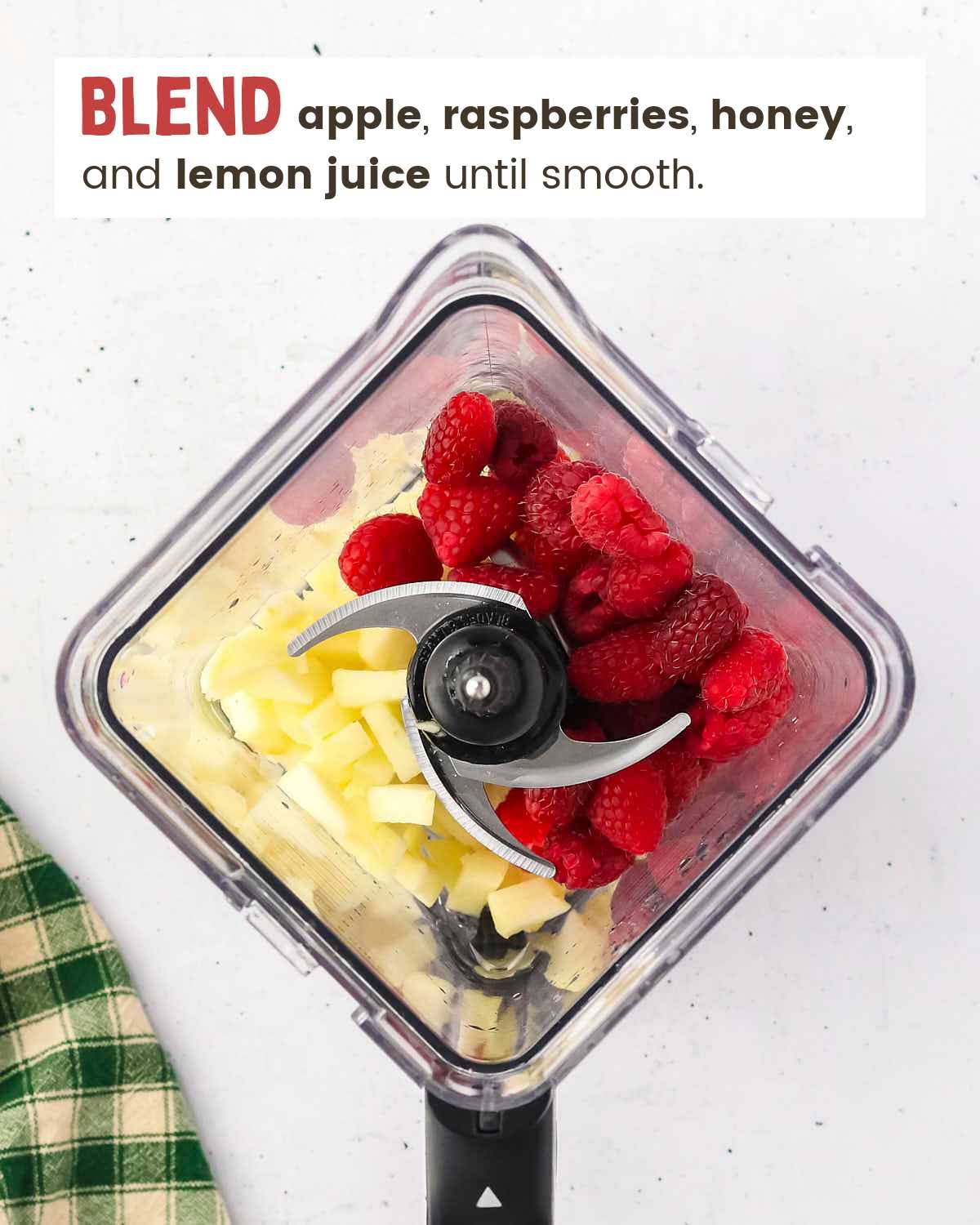 Apple chunks, raspberries, and honey in a blender. 