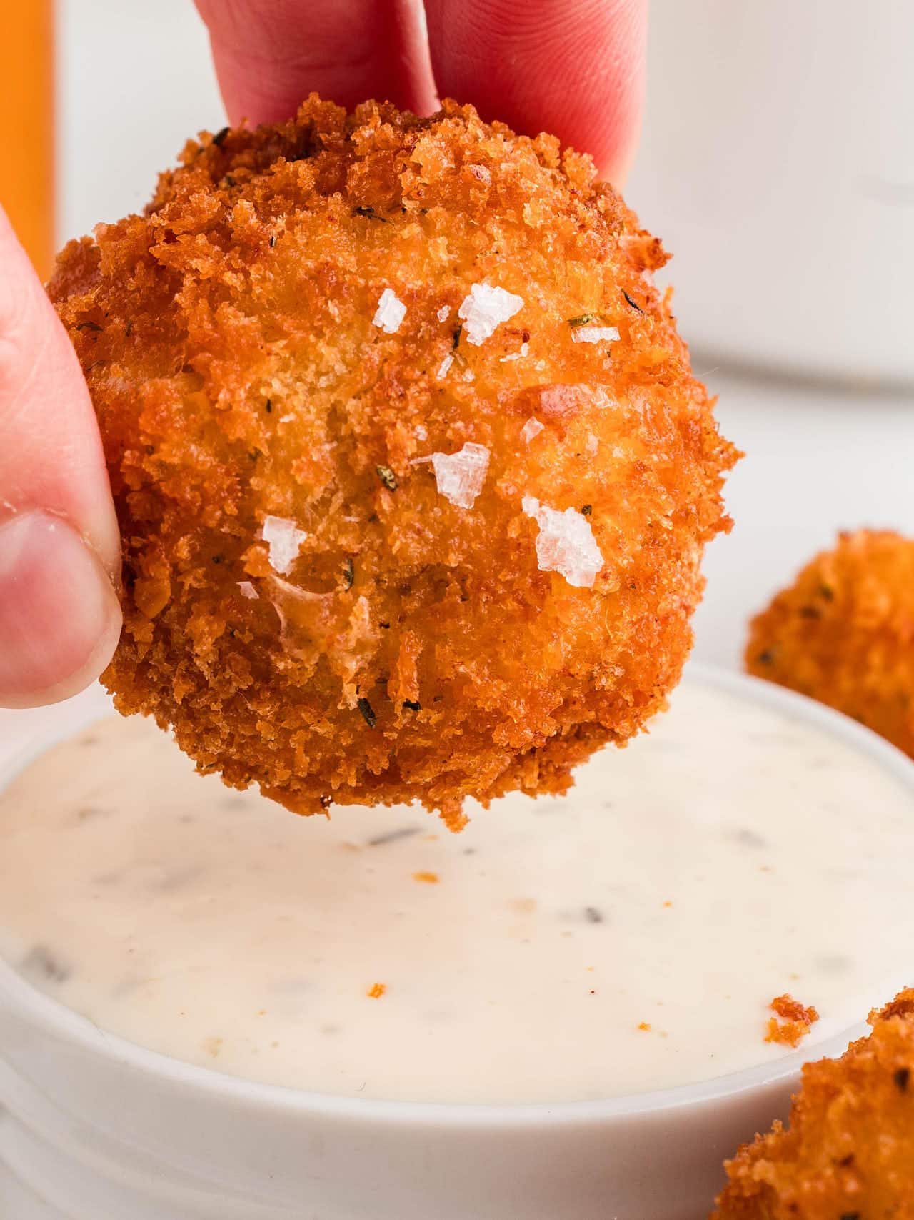 Dipping a Mac and Cheese Bite into dipping sauce.